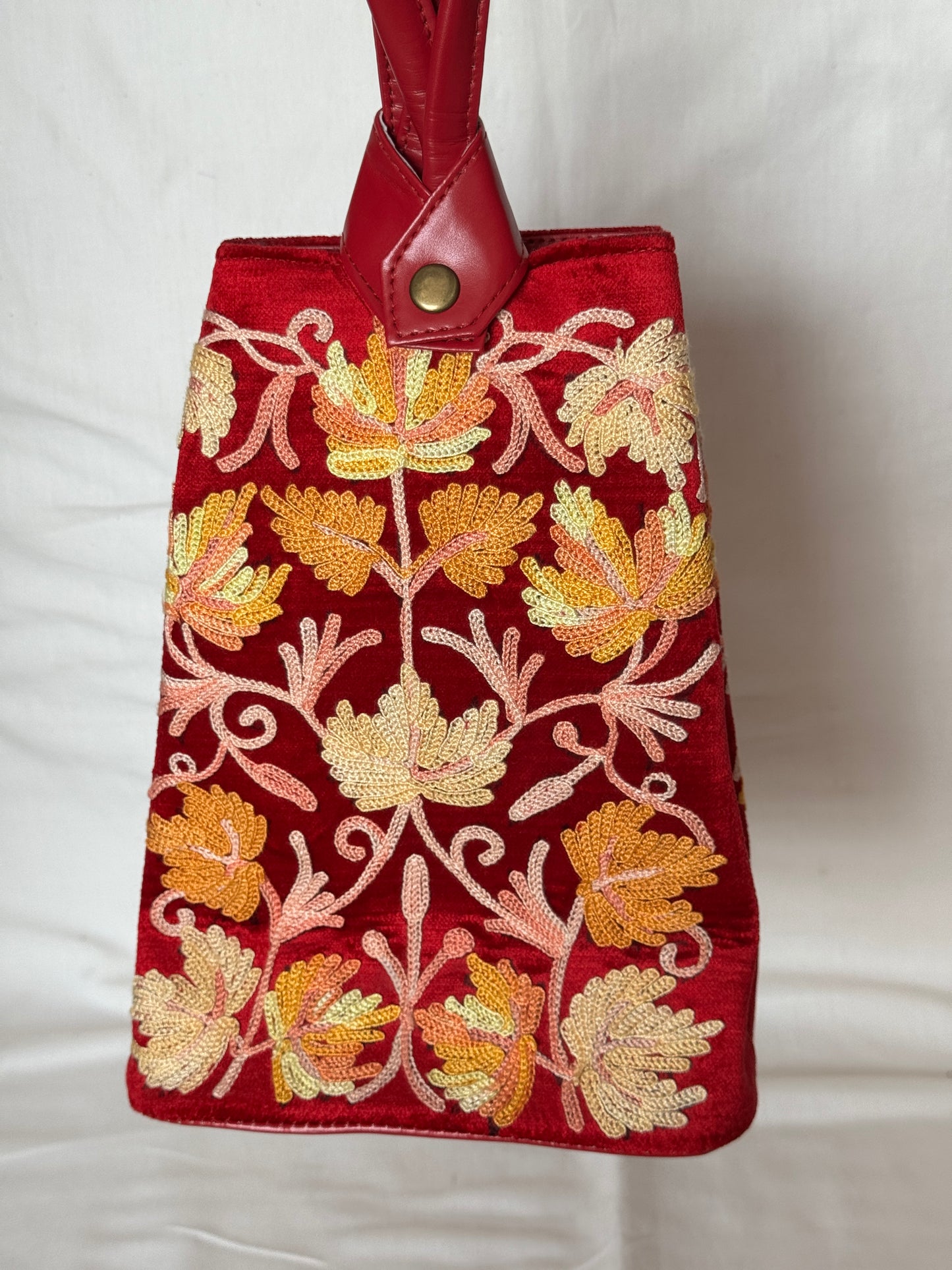 Potli bags with Kashmiri floral Aari embroidery - interesting twist around handle button closure