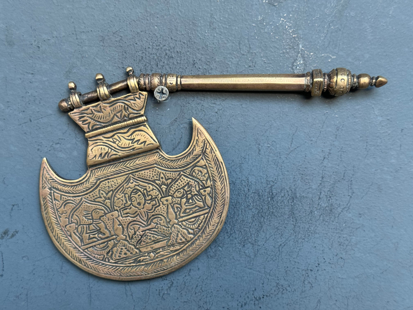 Vintage brass decorative fan with different engraved designs on both sides