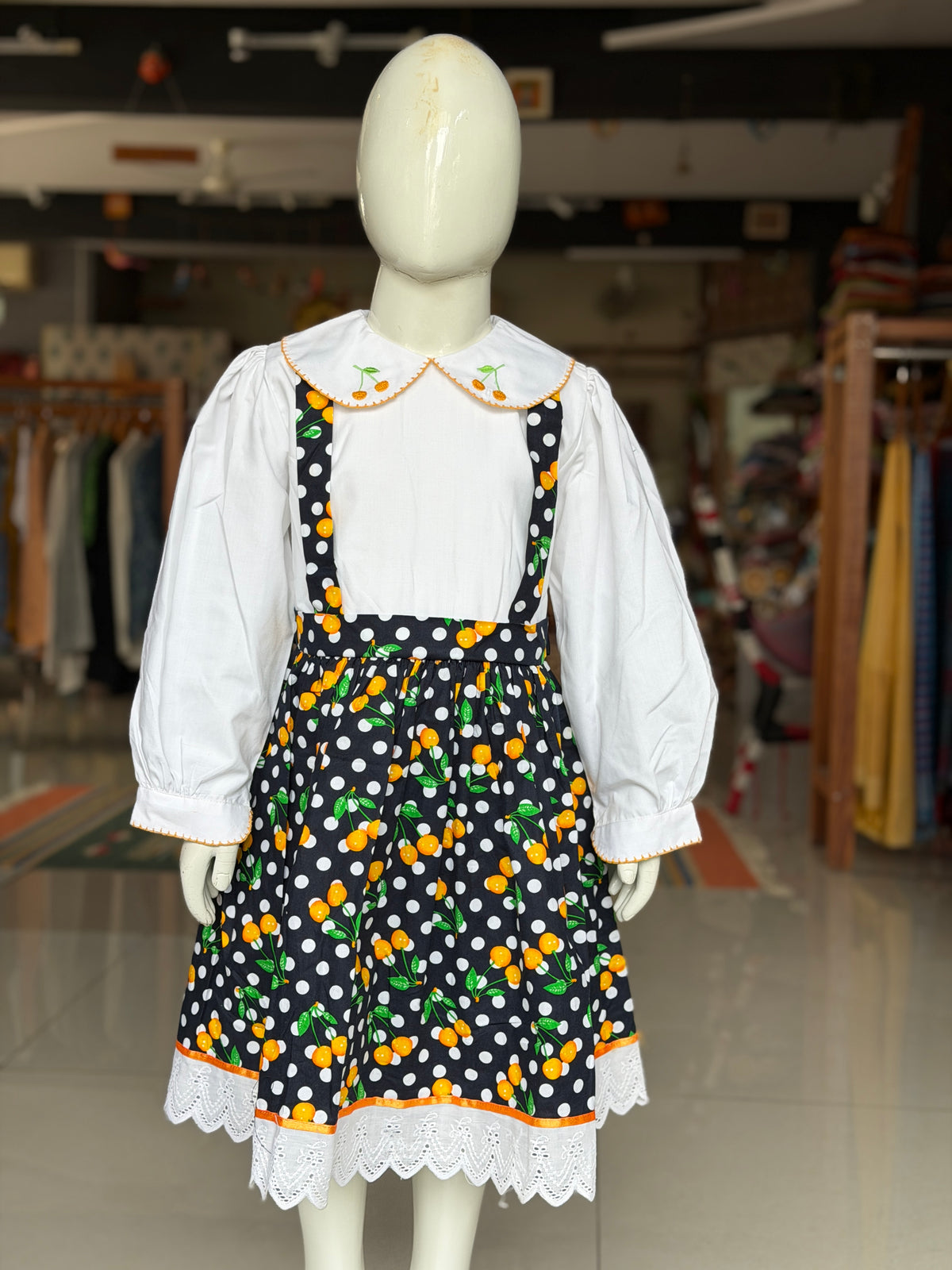 Black polka dots and cherries printed suspender look cotton frock with attached white  embroidered collared top for girls