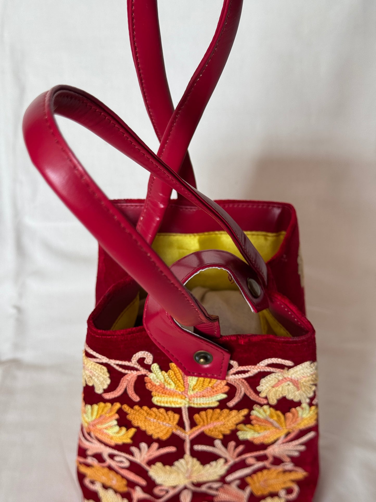 Potli bags with Kashmiri floral Aari embroidery - interesting twist around handle button closure
