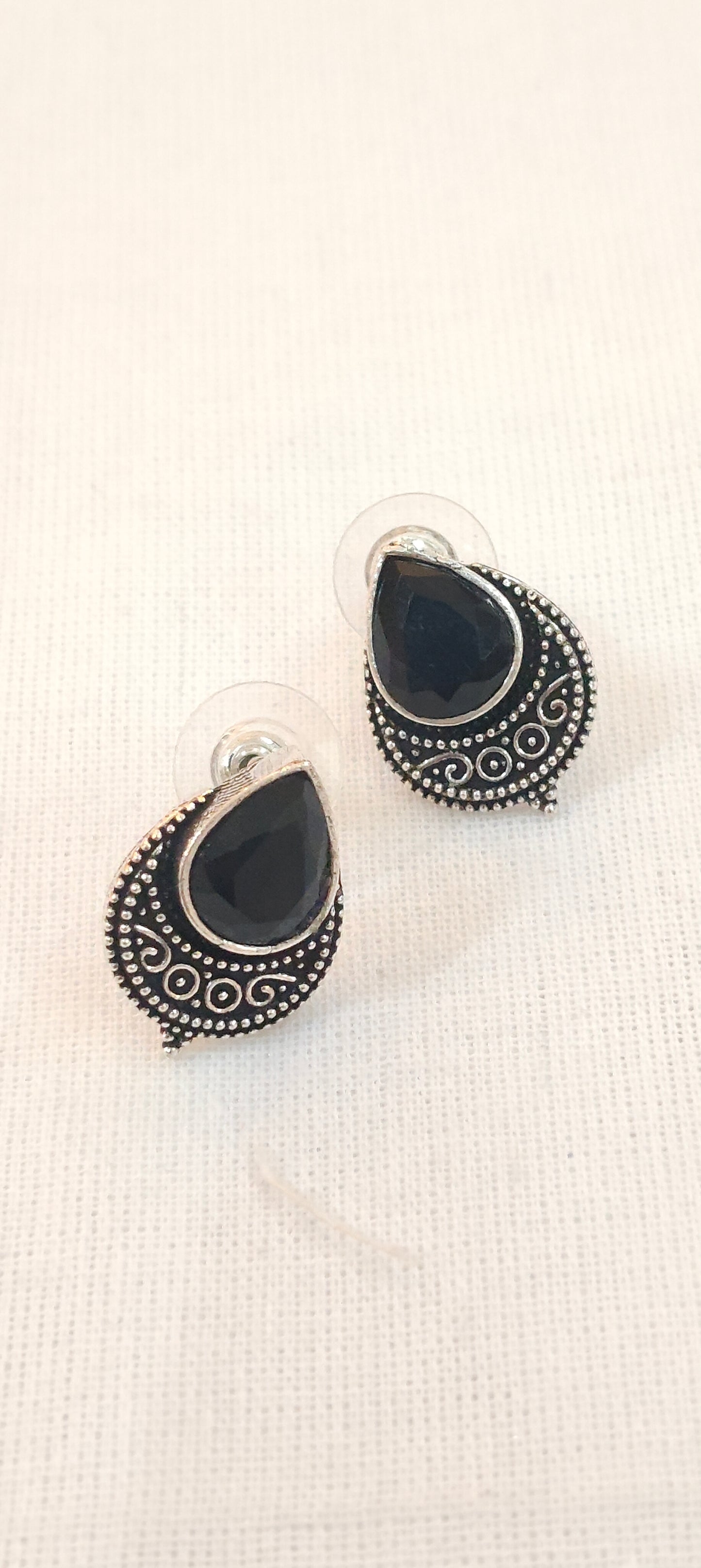 Black drop shaped stone stud earrings with silver detailing