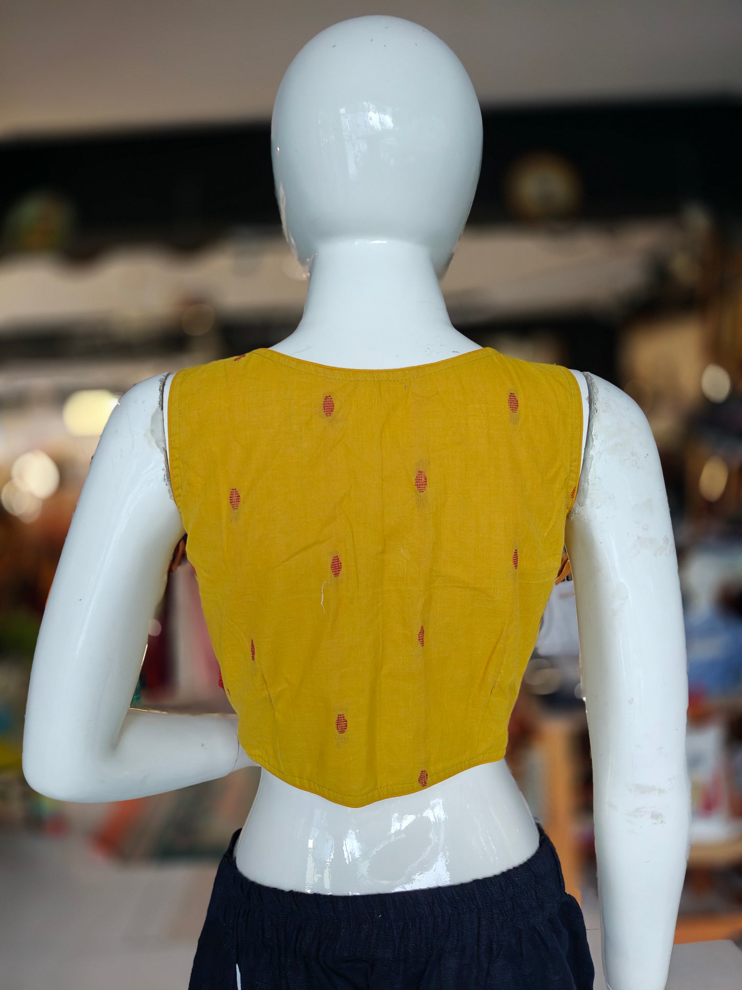 Mustard yellow dot prints front open sleeveless blouse with pads