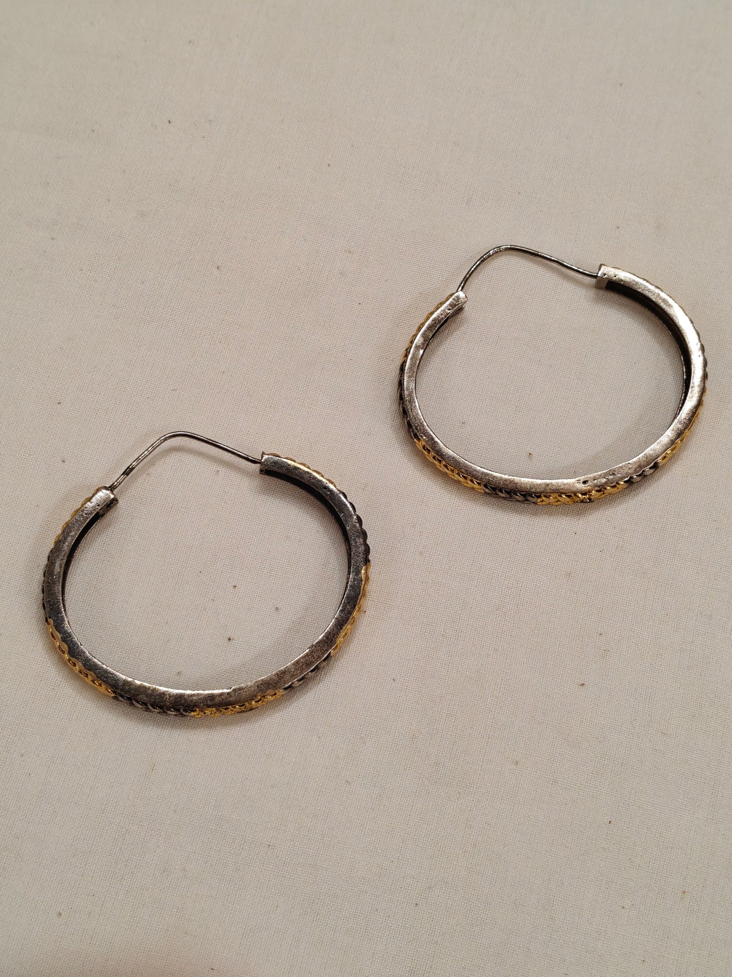 Gold and silver hoop earrings with braided design
