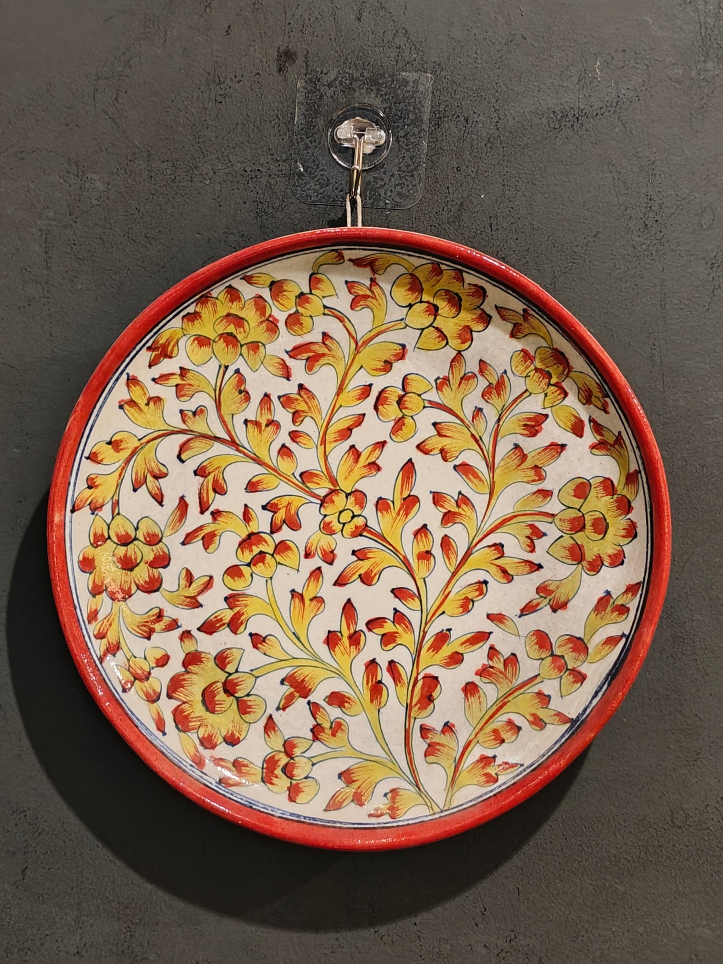 Blue pottery circular wall plate with yellow and orange handpainted flowers