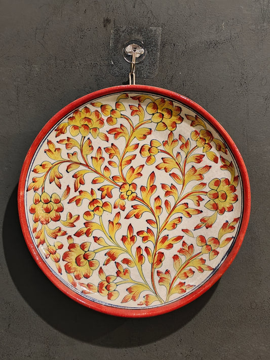 Blue pottery circular wall plate with yellow and orange handpainted flowers
