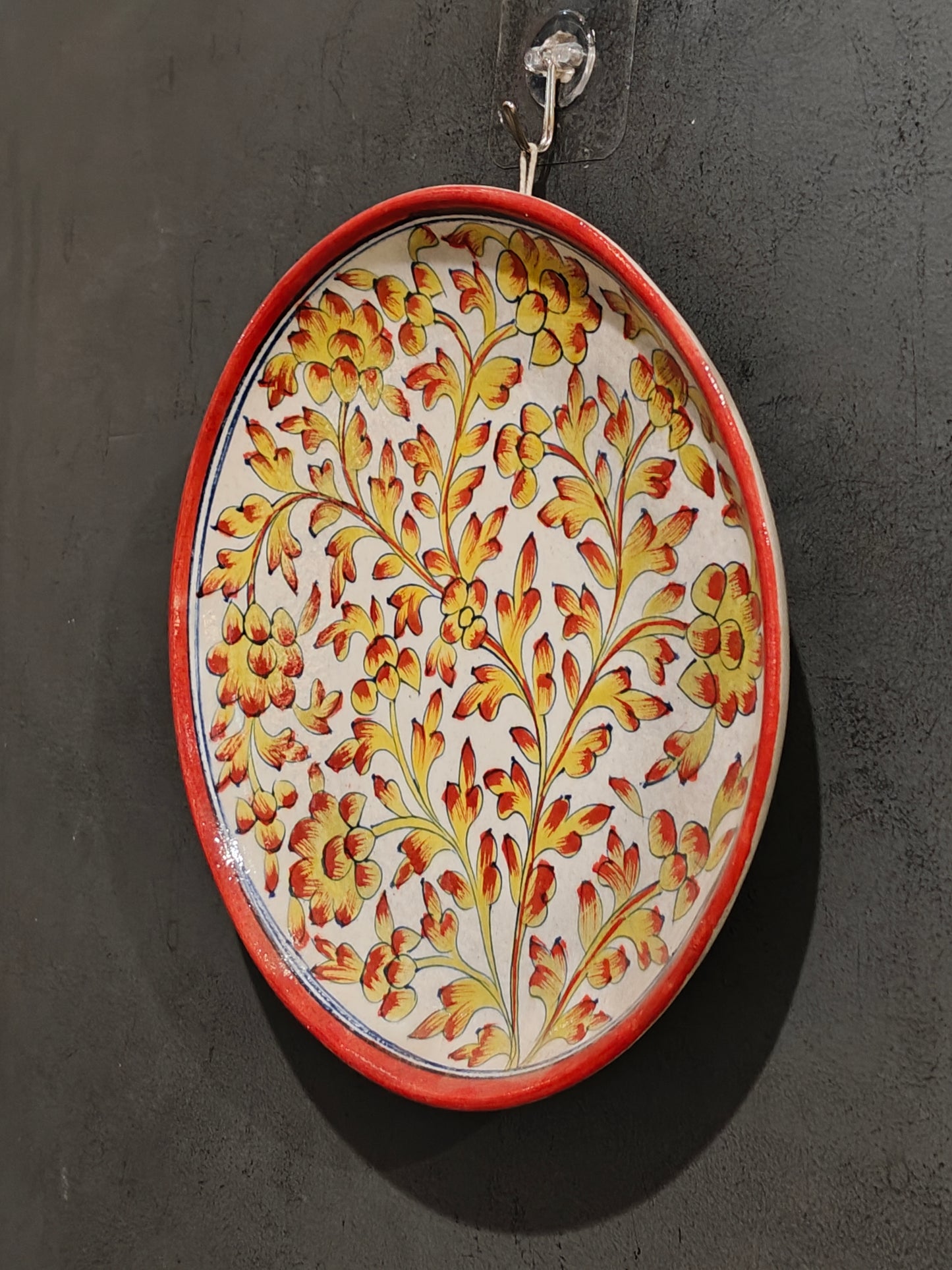 Blue pottery circular wall plate with yellow and orange handpainted flowers