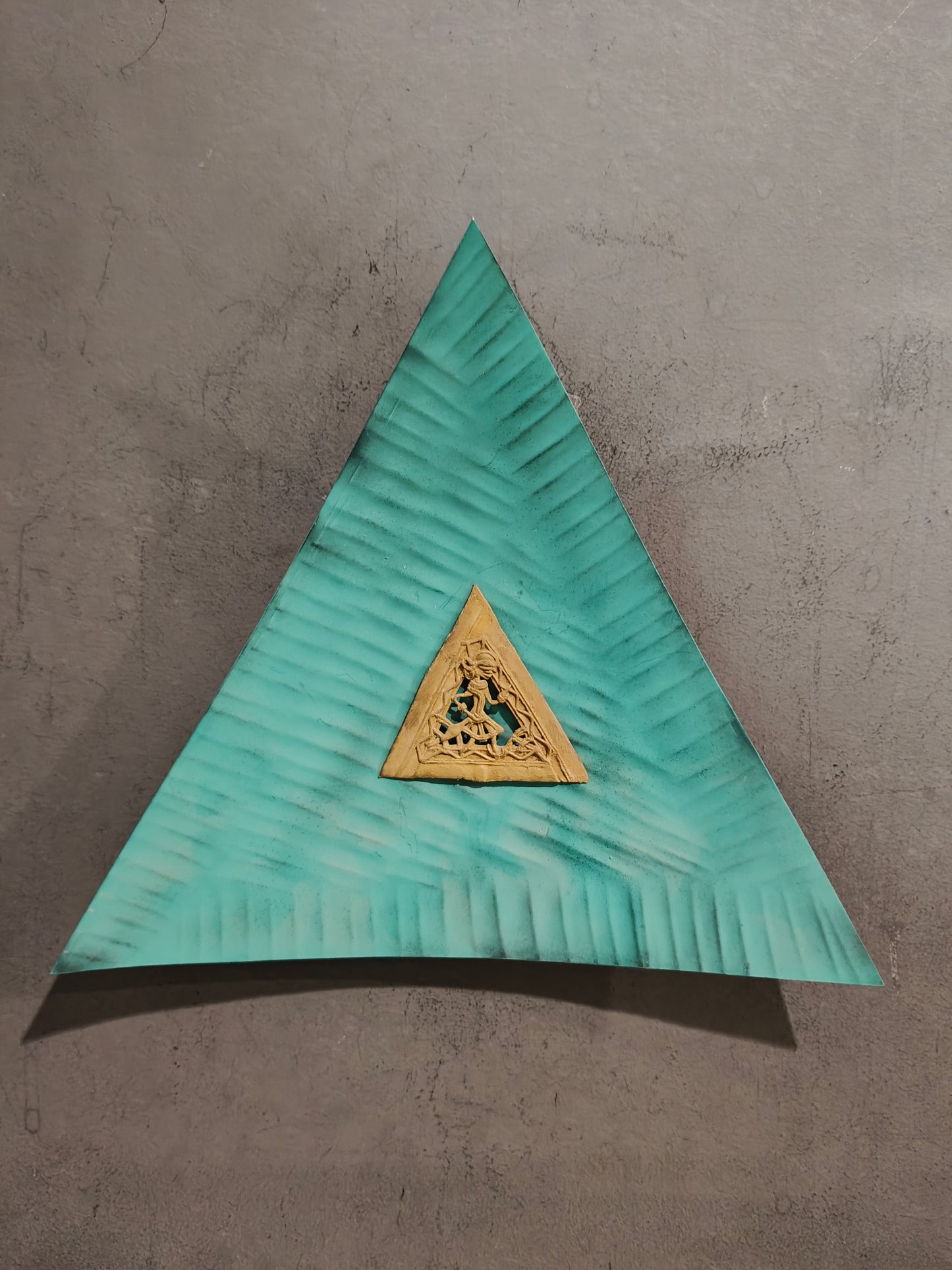 Green concave triangle with brass dokra frame in the middle