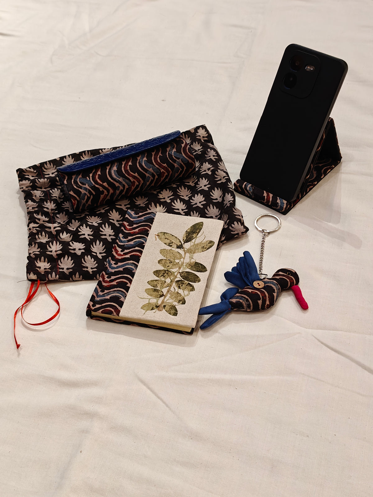 Handmade paper notebook with eco leaf printed fabric cover, bird design key ring / bag charm, mobile stand, spectacles box and a potli - gift set