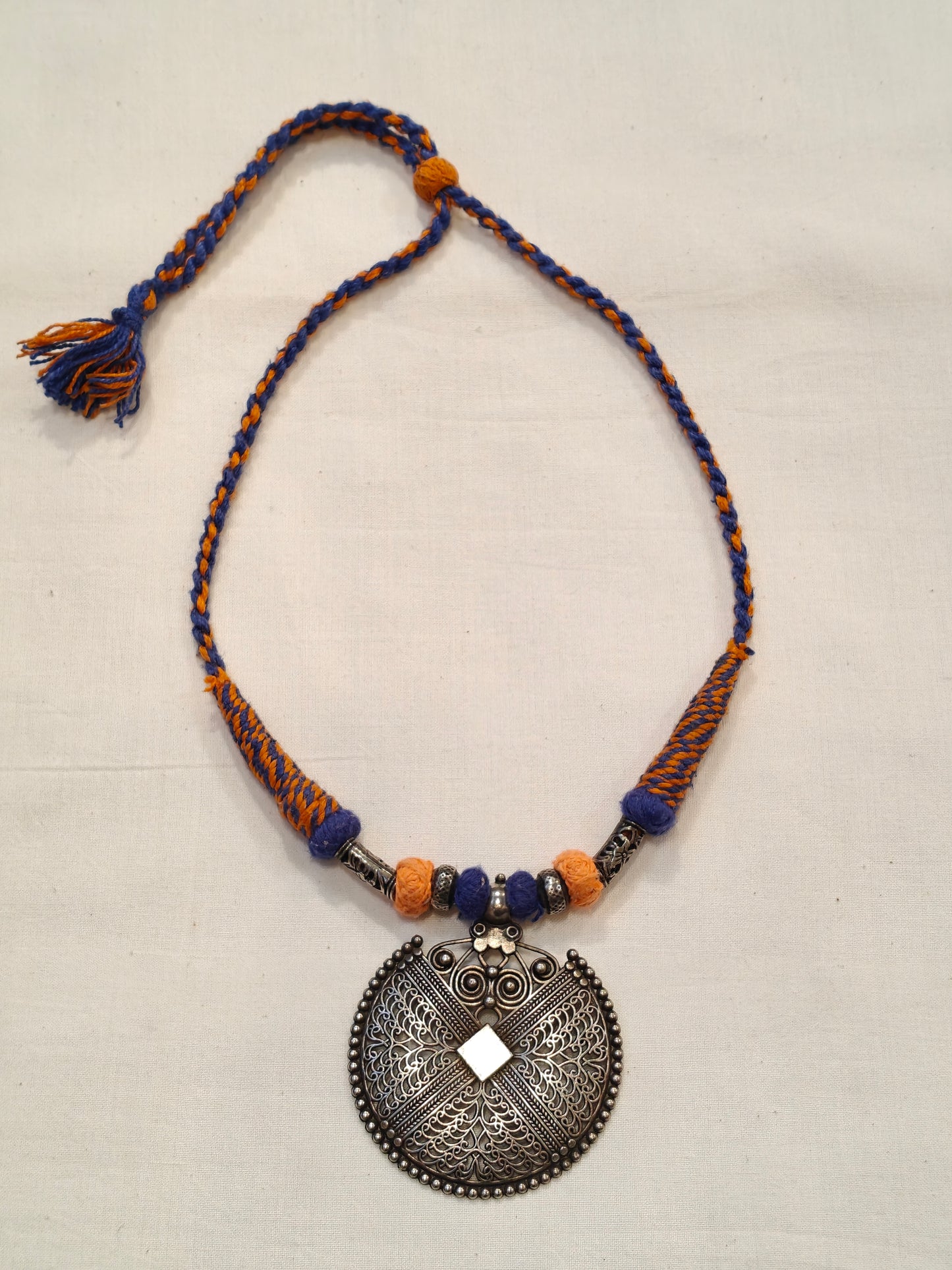 Orange and blue thread with circular pendant oxidised neckpiece