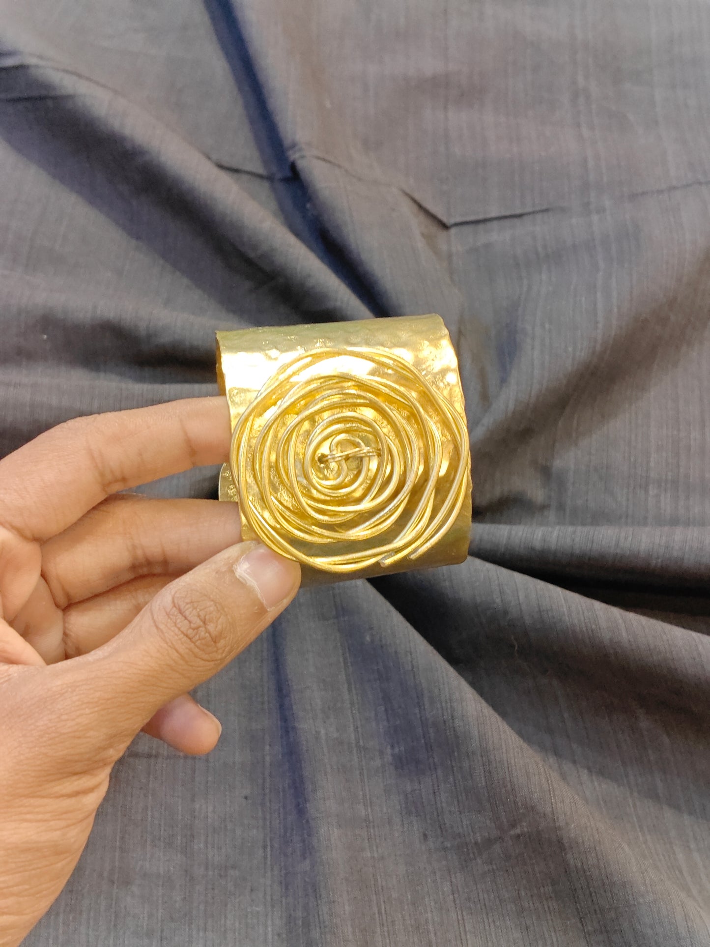Handcrafted cuff bracelet in brass with hammered finish and floral design on top