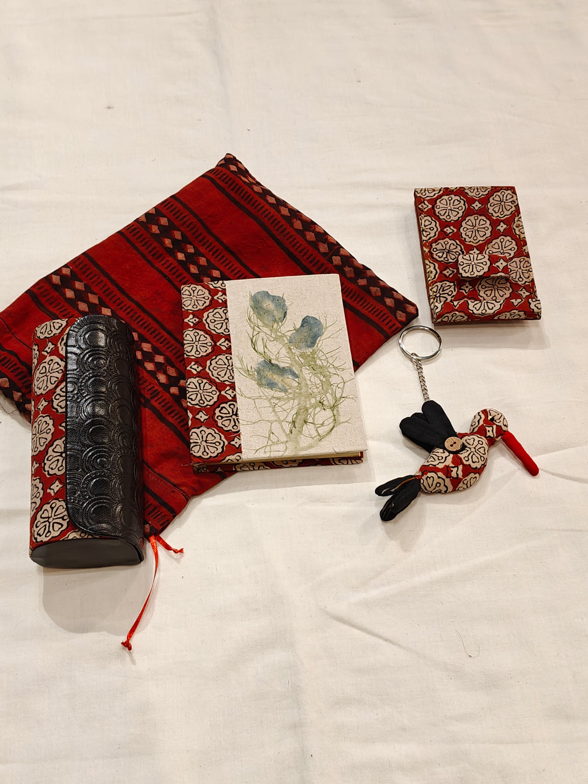 Handmade paper notebook with eco leaf printed fabric cover, bird design key ring / bag charm, mobile stand, spectacles box and a potli - gift set