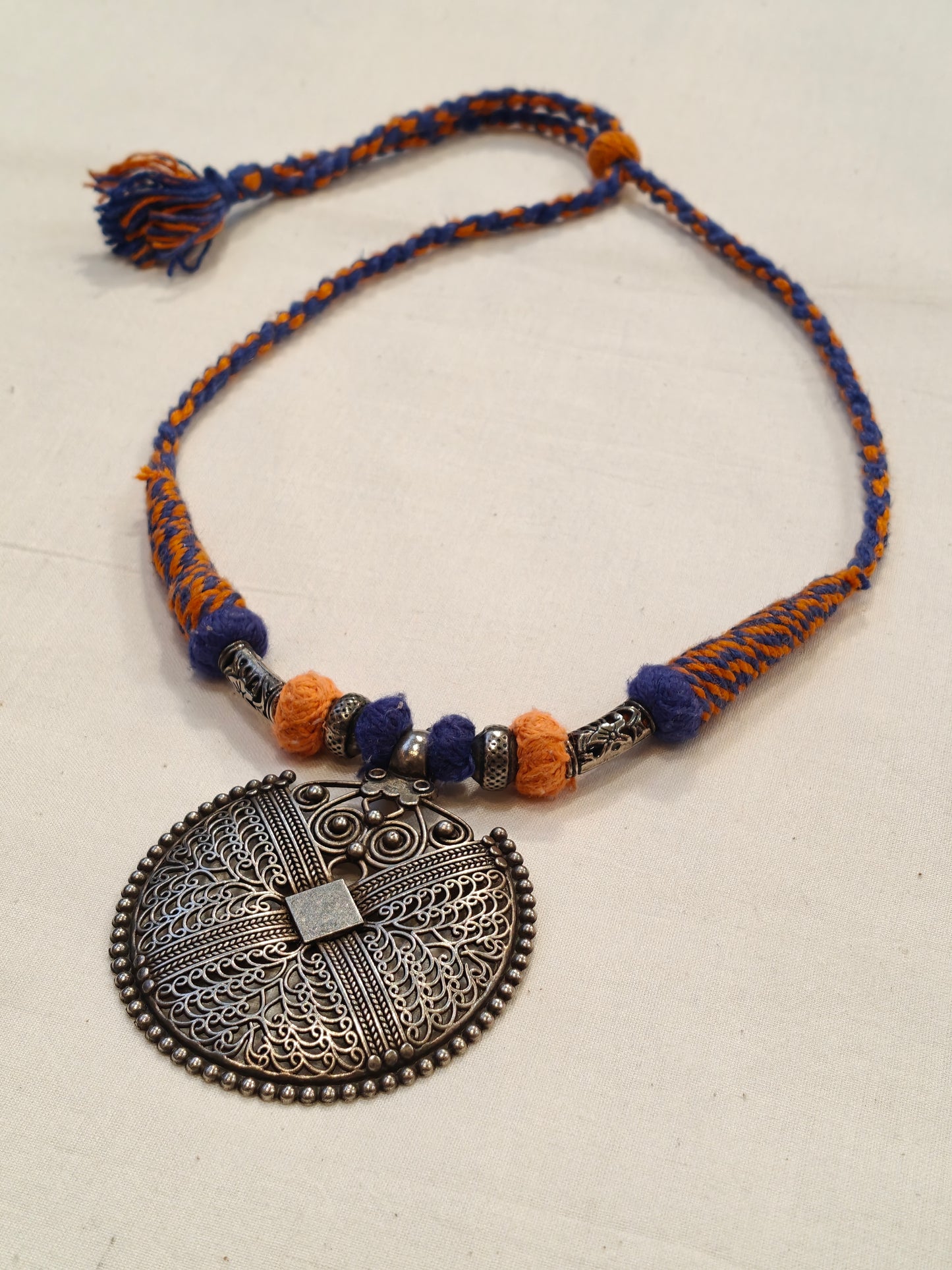 Orange and blue thread with circular pendant oxidised neckpiece