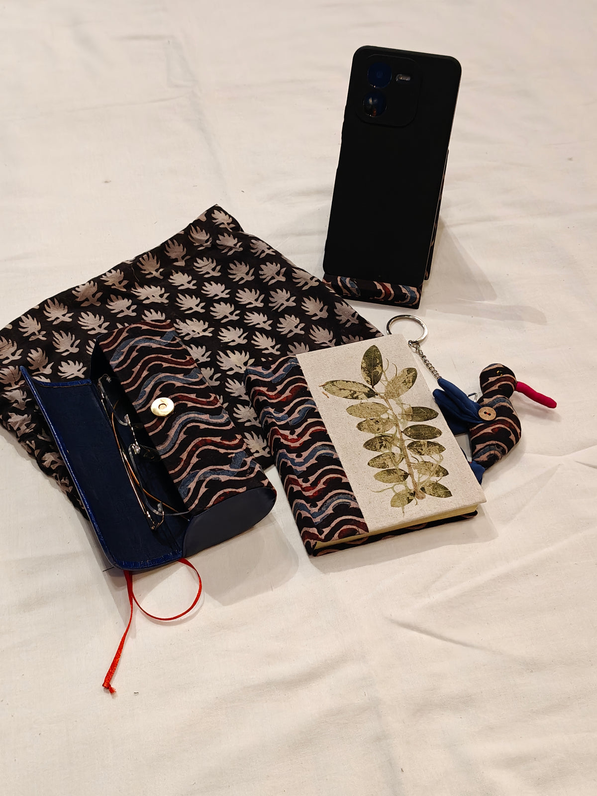 Handmade paper notebook with eco leaf printed fabric cover, bird design key ring / bag charm, mobile stand, spectacles box and a potli - gift set