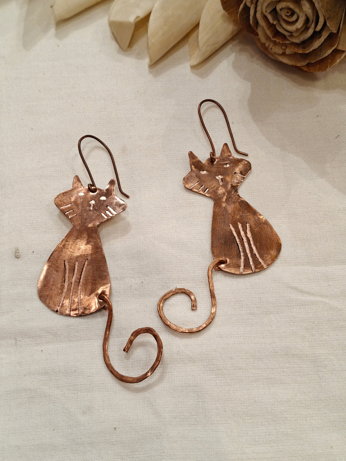 Copper cat dangle earrings featuring a charming curly tail design