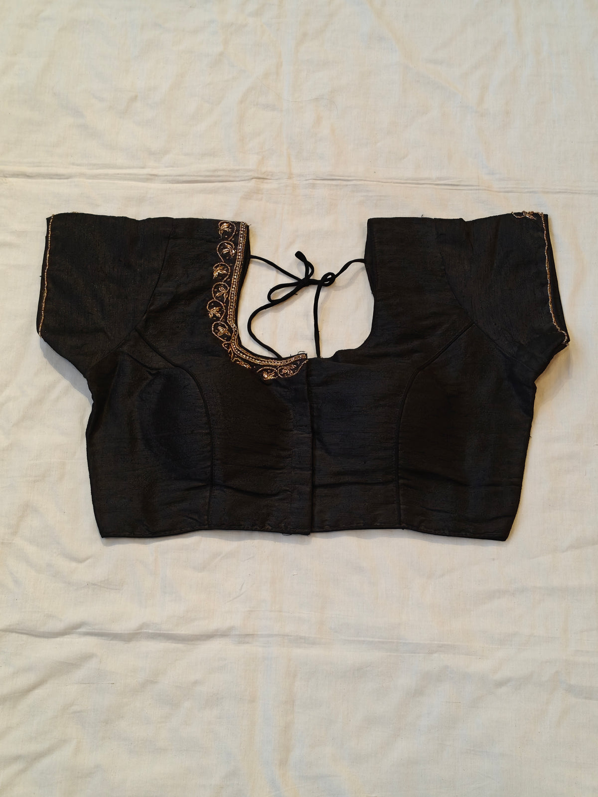 Black short sleeved blouse with beaded embroidery along the neckline and sleeves