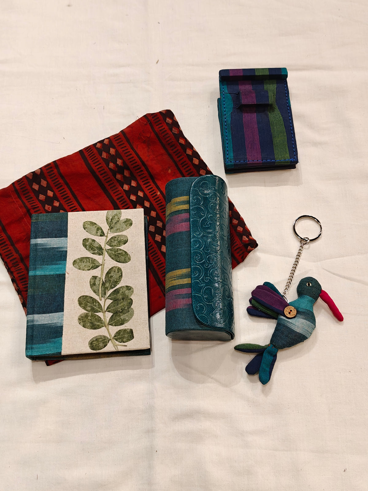 Handmade paper notebook with eco leaf printed fabric cover, bird design key ring / bag charm, mobile stand, spectacles box and a potli - gift set