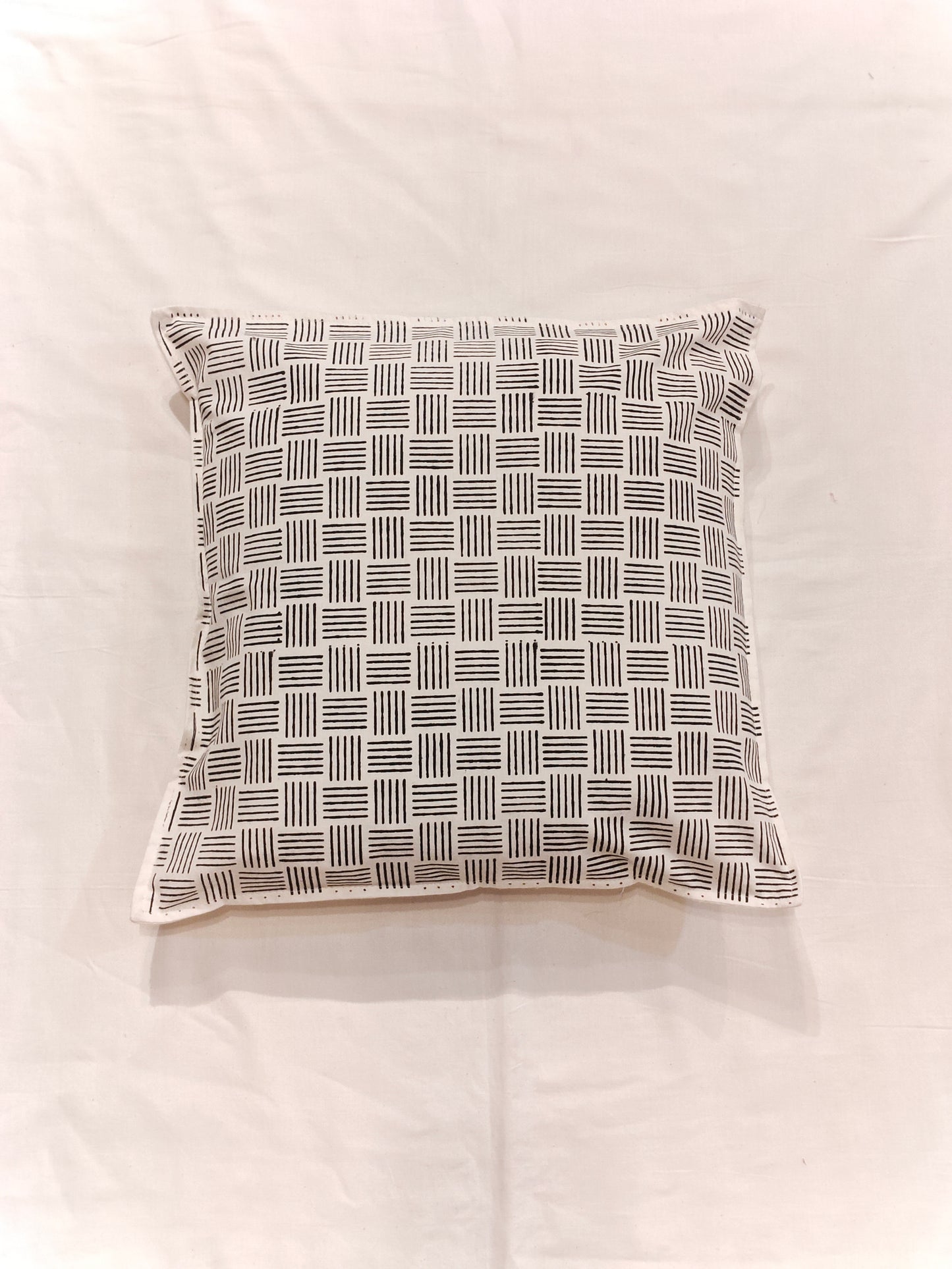 White cushion cover featuring horizontal and vertical stripes