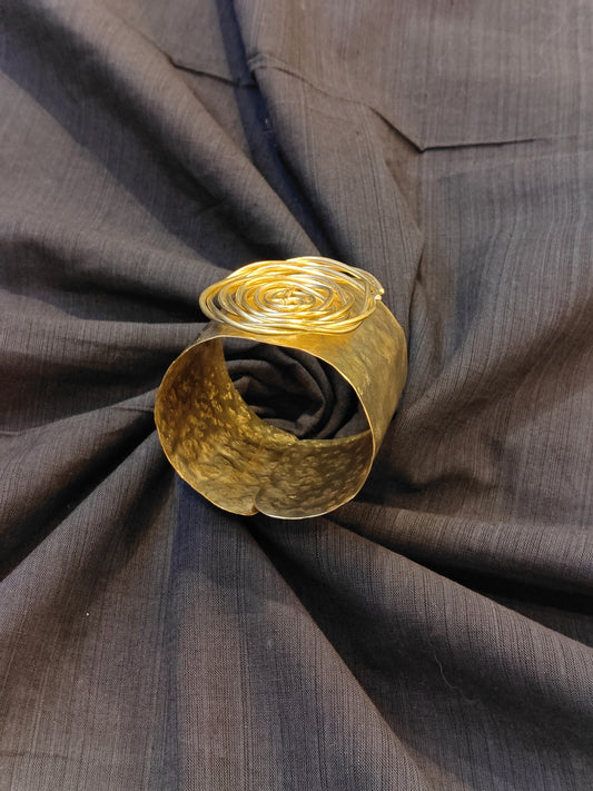 Handcrafted cuff bracelet in brass with hammered finish and floral design on top