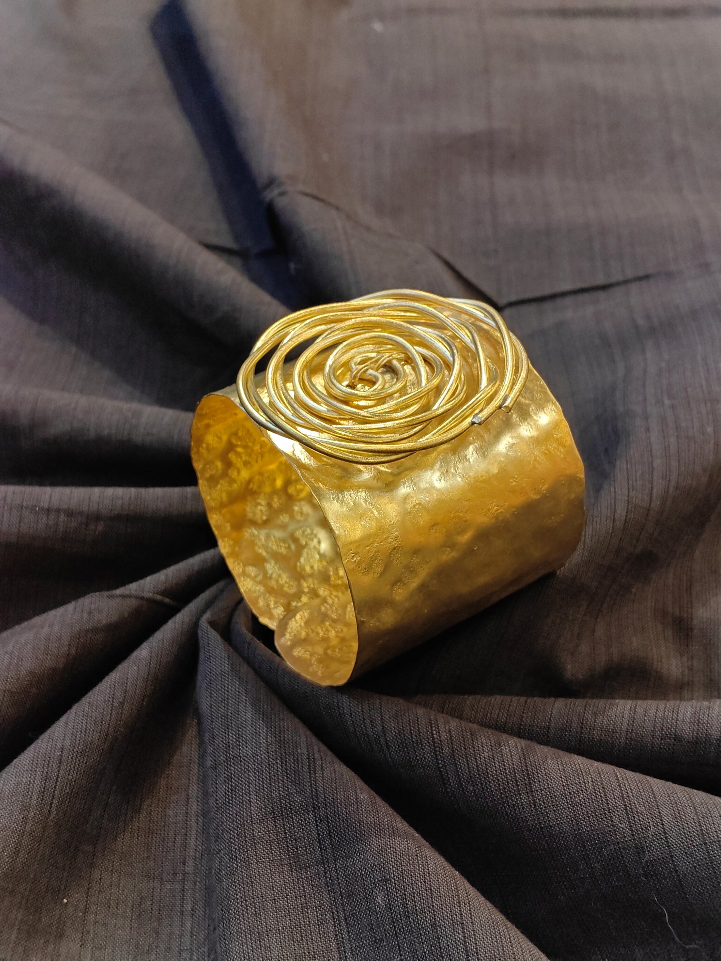Handcrafted cuff bracelet in brass with hammered finish and floral design on top