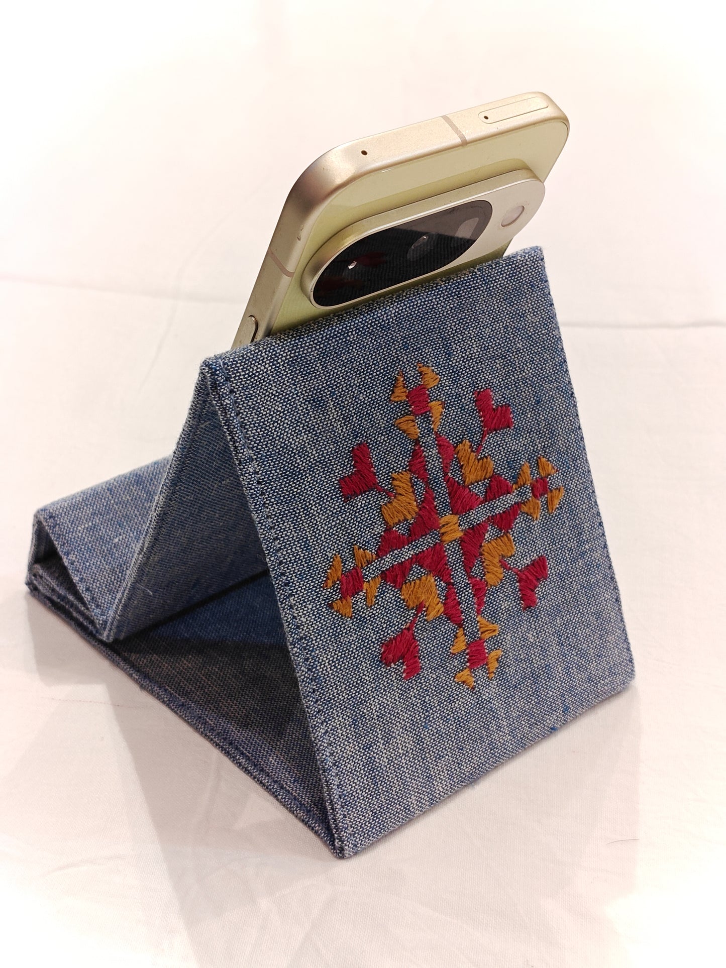Light blue foldable fabric phone stand featuring decorative Phulkari hand embroidery