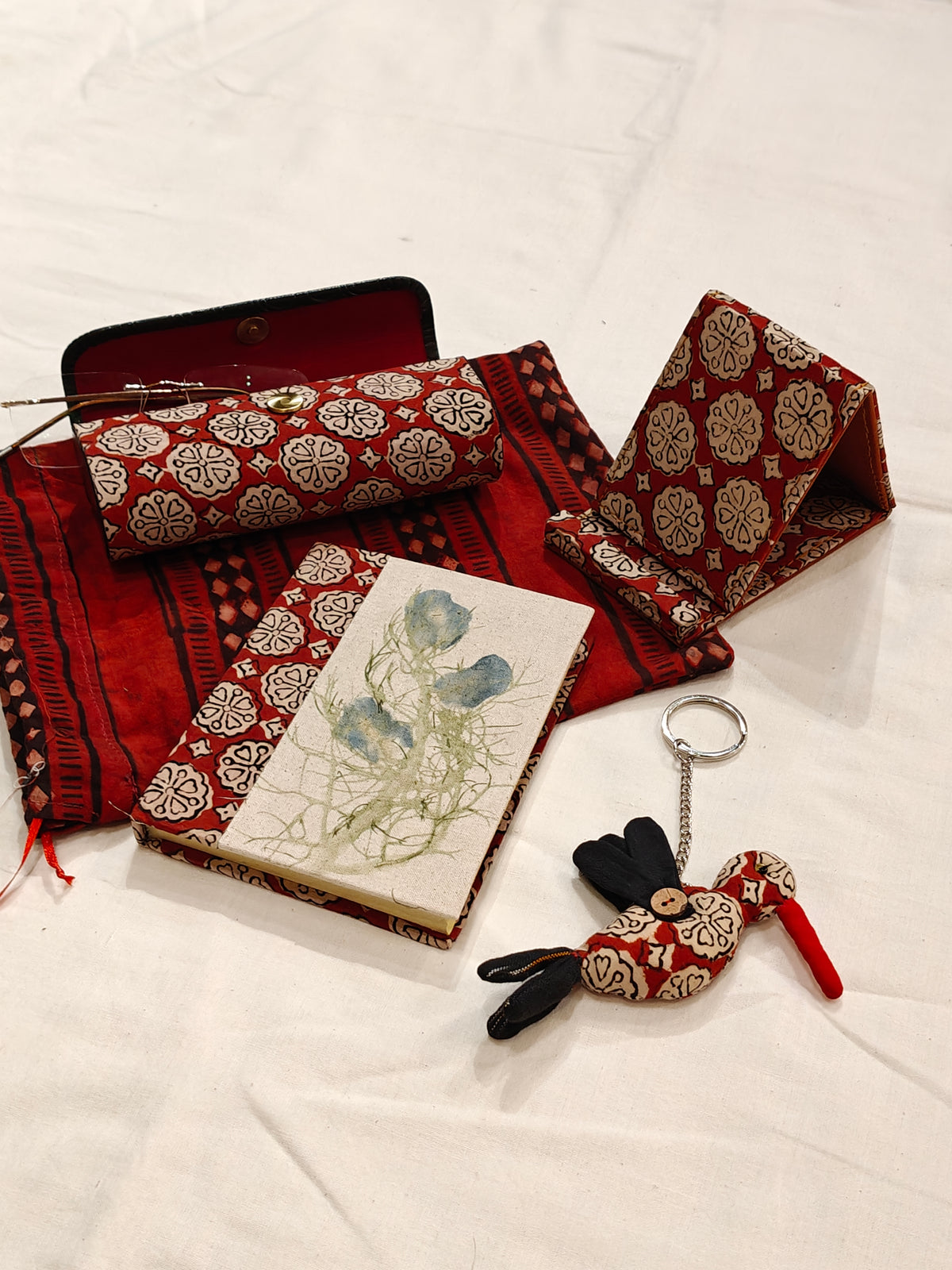 Handmade paper notebook with eco leaf printed fabric cover, bird design key ring / bag charm, mobile stand, spectacles box and a potli - gift set