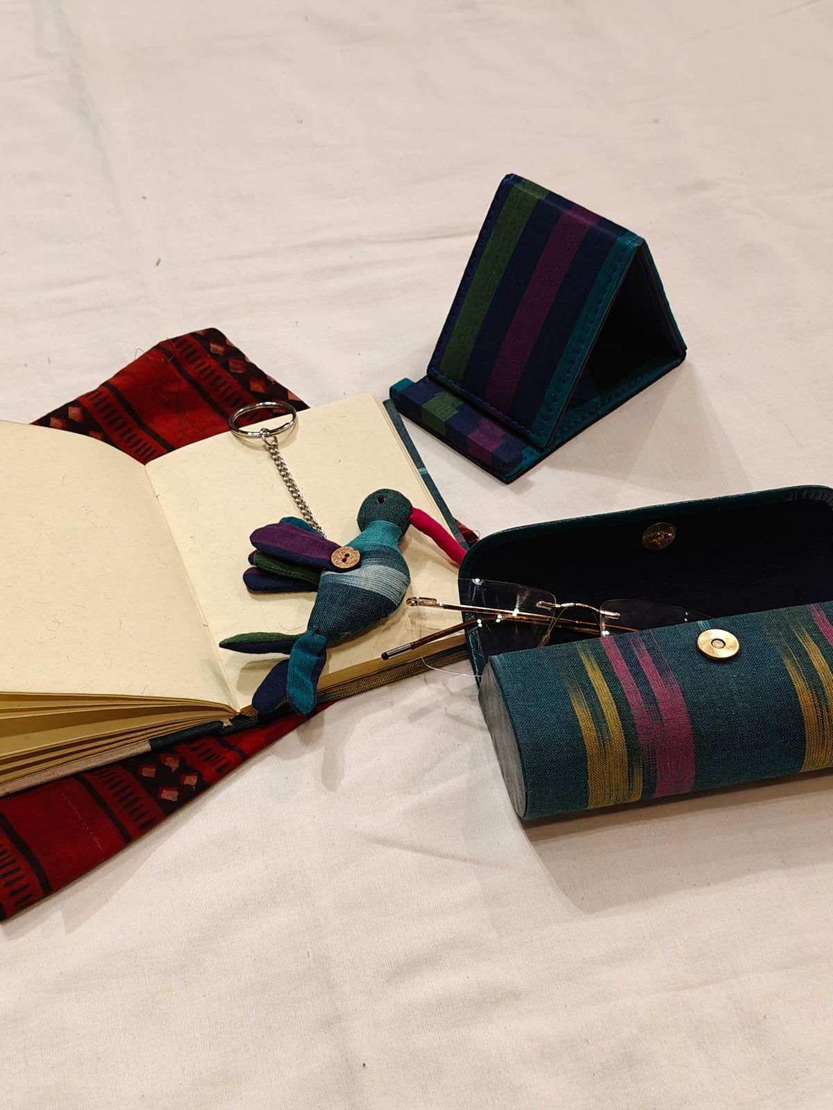 Handmade paper notebook with eco leaf printed fabric cover, bird design key ring / bag charm, mobile stand, spectacles box and a potli - gift set
