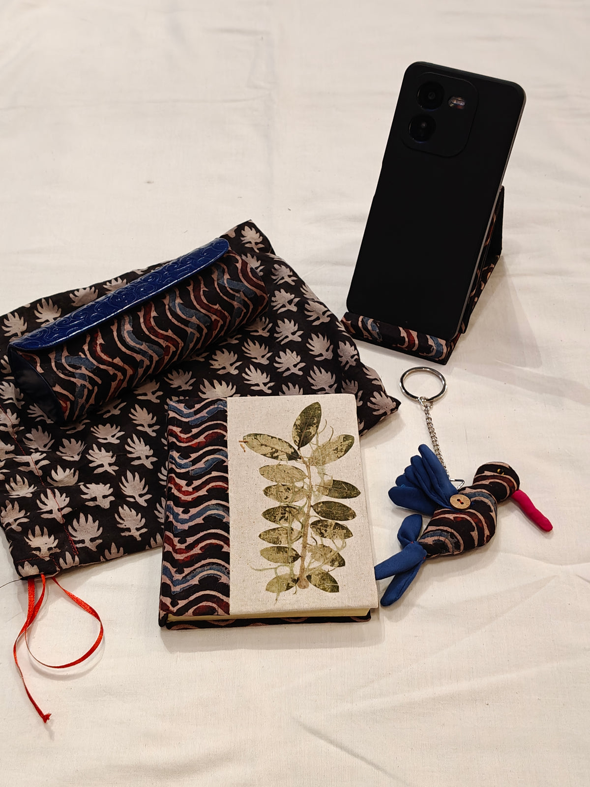 Handmade paper notebook with eco leaf printed fabric cover, bird design key ring / bag charm, mobile stand, spectacles box and a potli - gift set