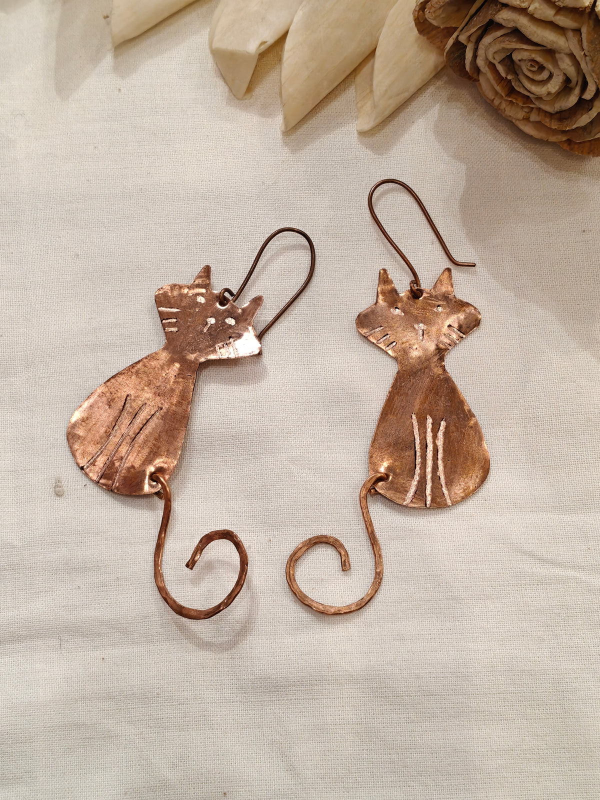 Copper cat dangle earrings featuring a charming curly tail design