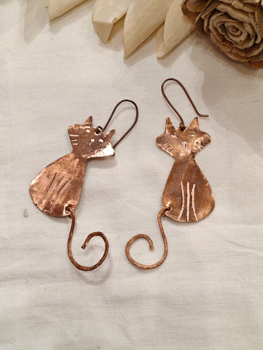 Copper cat dangle earrings featuring a charming curly tail design