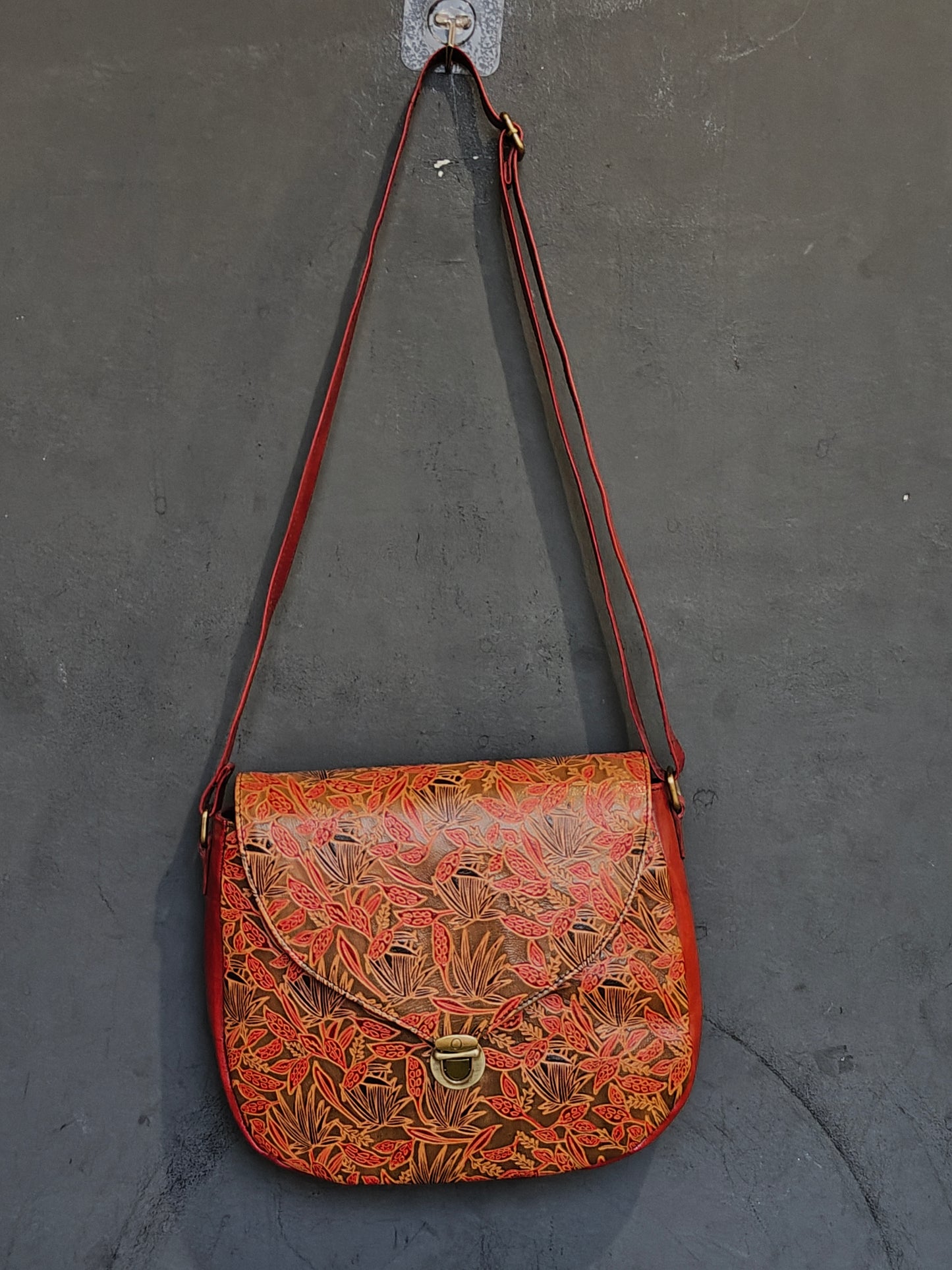 Leather hand crafted, hand painted adjustable length sling bag with metal clasp