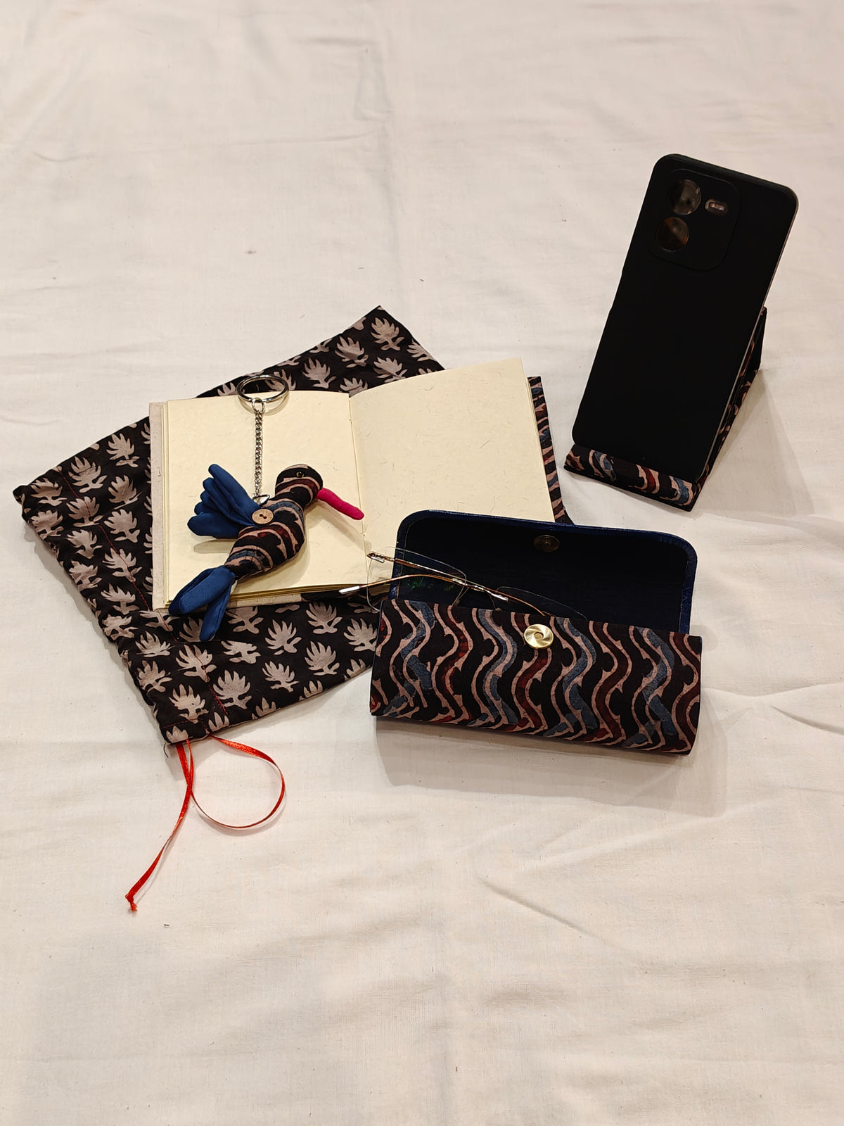 Handmade paper notebook with eco leaf printed fabric cover, bird design key ring / bag charm, mobile stand, spectacles box and a potli - gift set