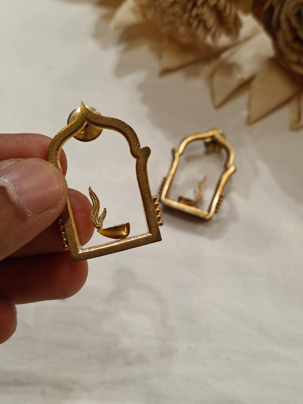 Jharokha frame enclosing burning diya design brass stud earrings