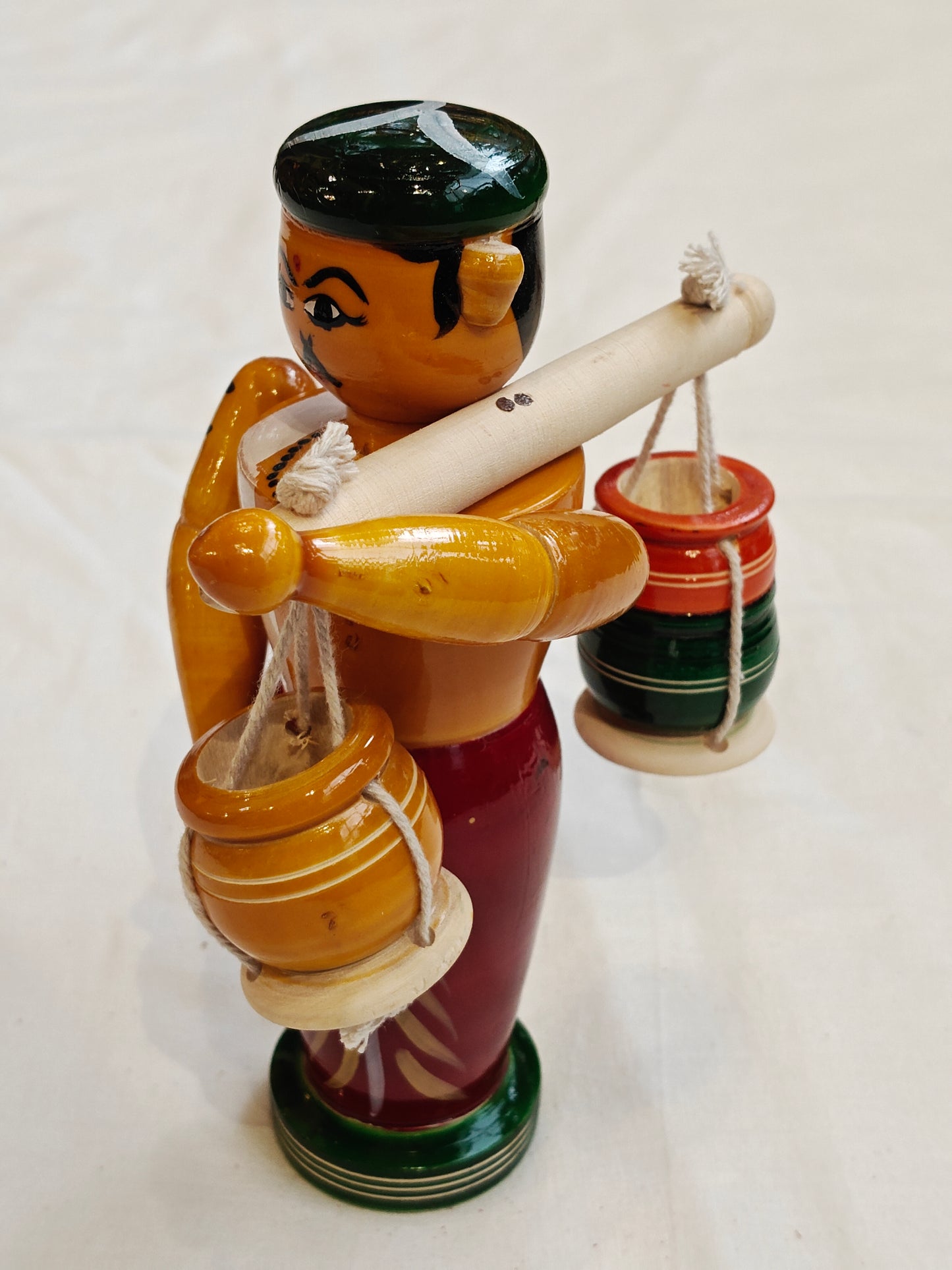 Man carrying pots by shoulder pole - Handcrafted wooden decor