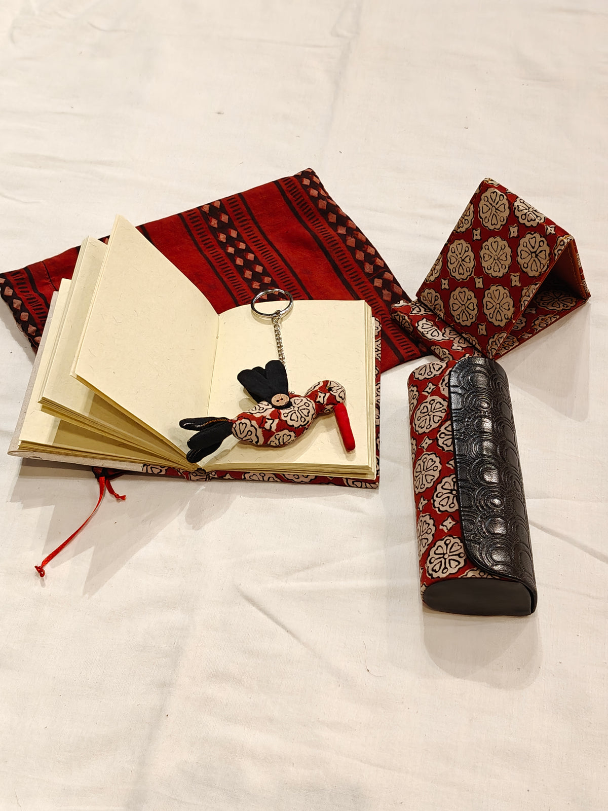 Handmade paper notebook with eco leaf printed fabric cover, bird design key ring / bag charm, mobile stand, spectacles box and a potli - gift set