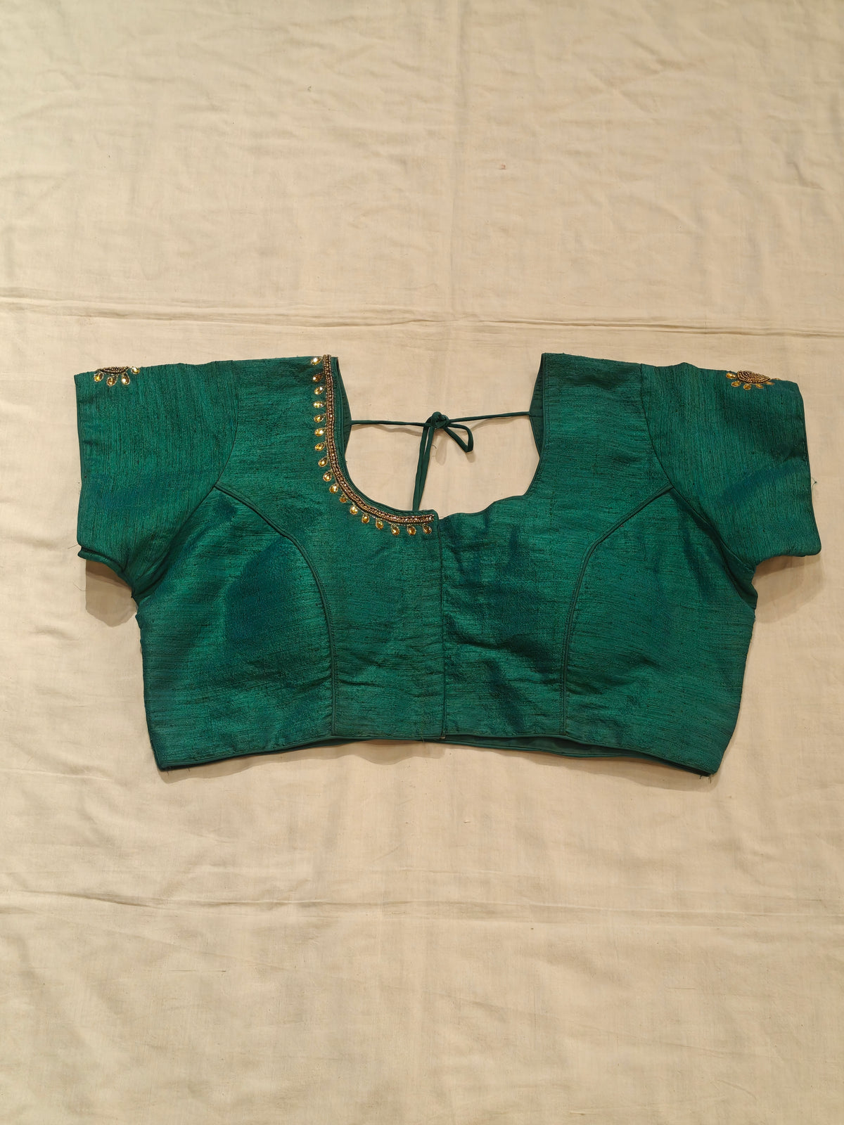 Green short sleeved blouse with beaded embroidery along the neckline and sleeves with peacock motif on back