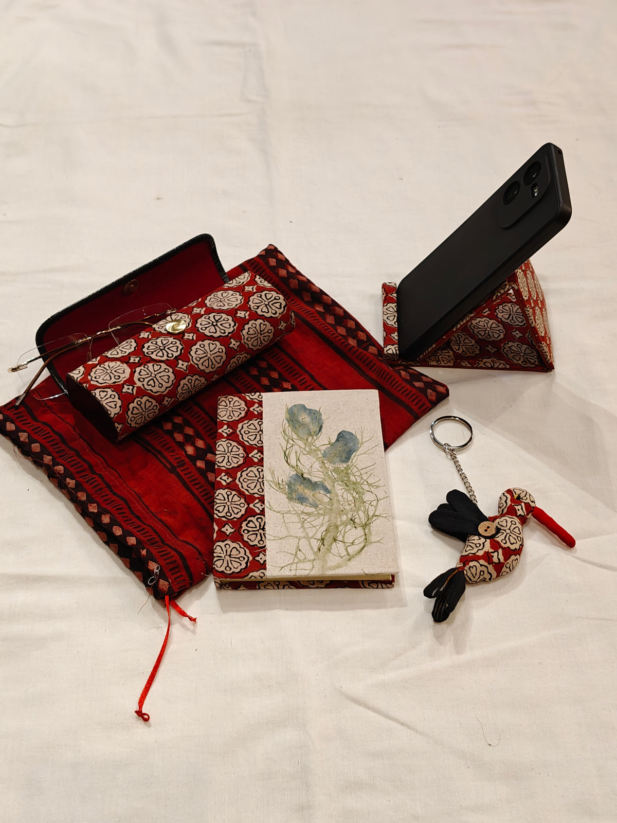 Handmade paper notebook with eco leaf printed fabric cover, bird design key ring / bag charm, mobile stand, spectacles box and a potli - gift set