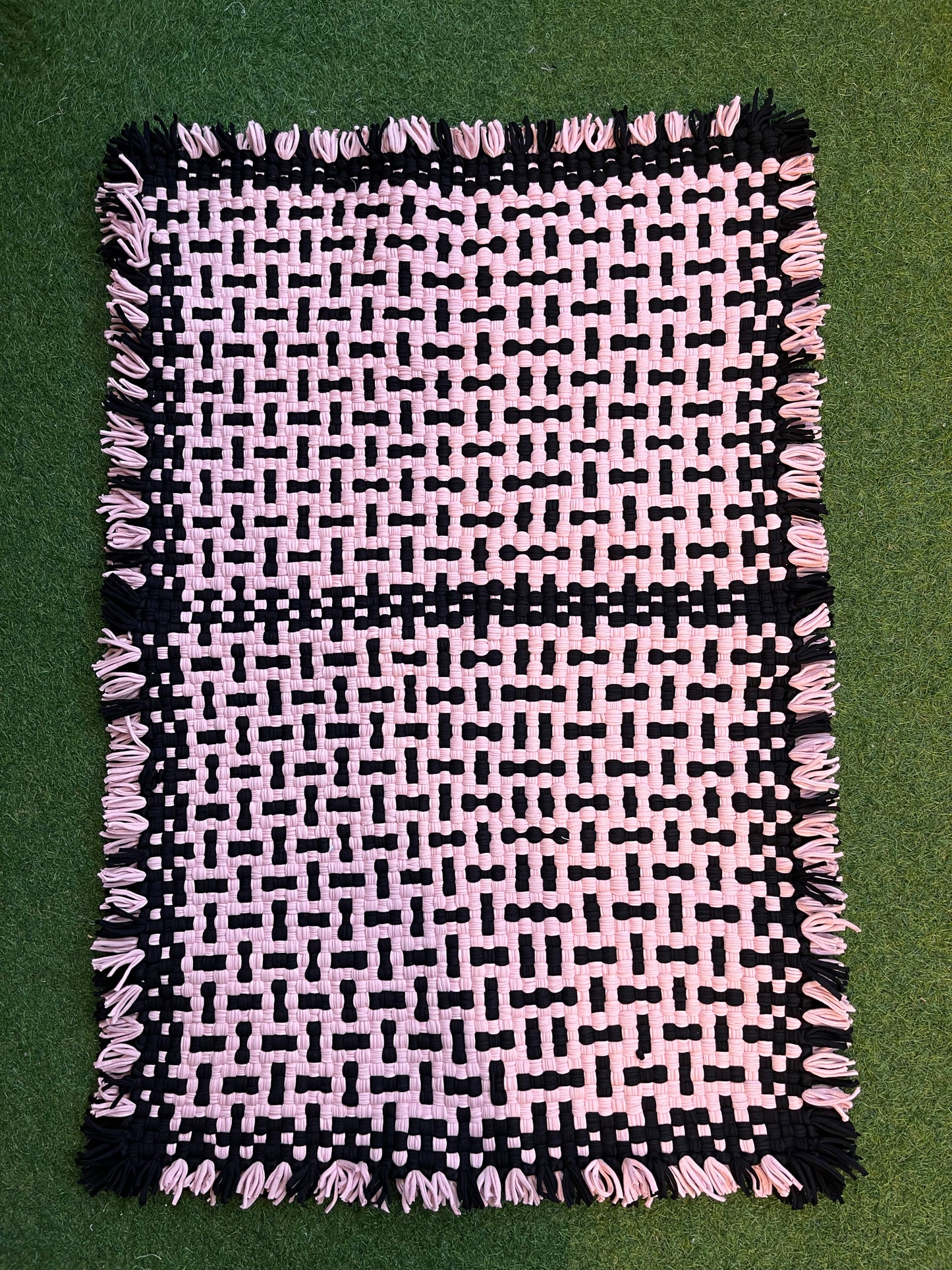 Pink and black handwoven upcycled knitted cotton rug